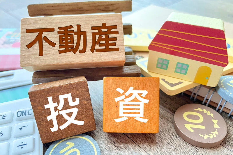 不動産と投資の文字、電卓と小銭